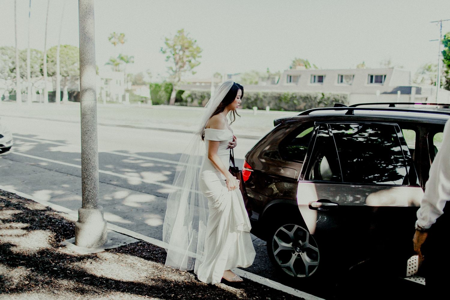 bride entering car heading to ceremony and reception venue