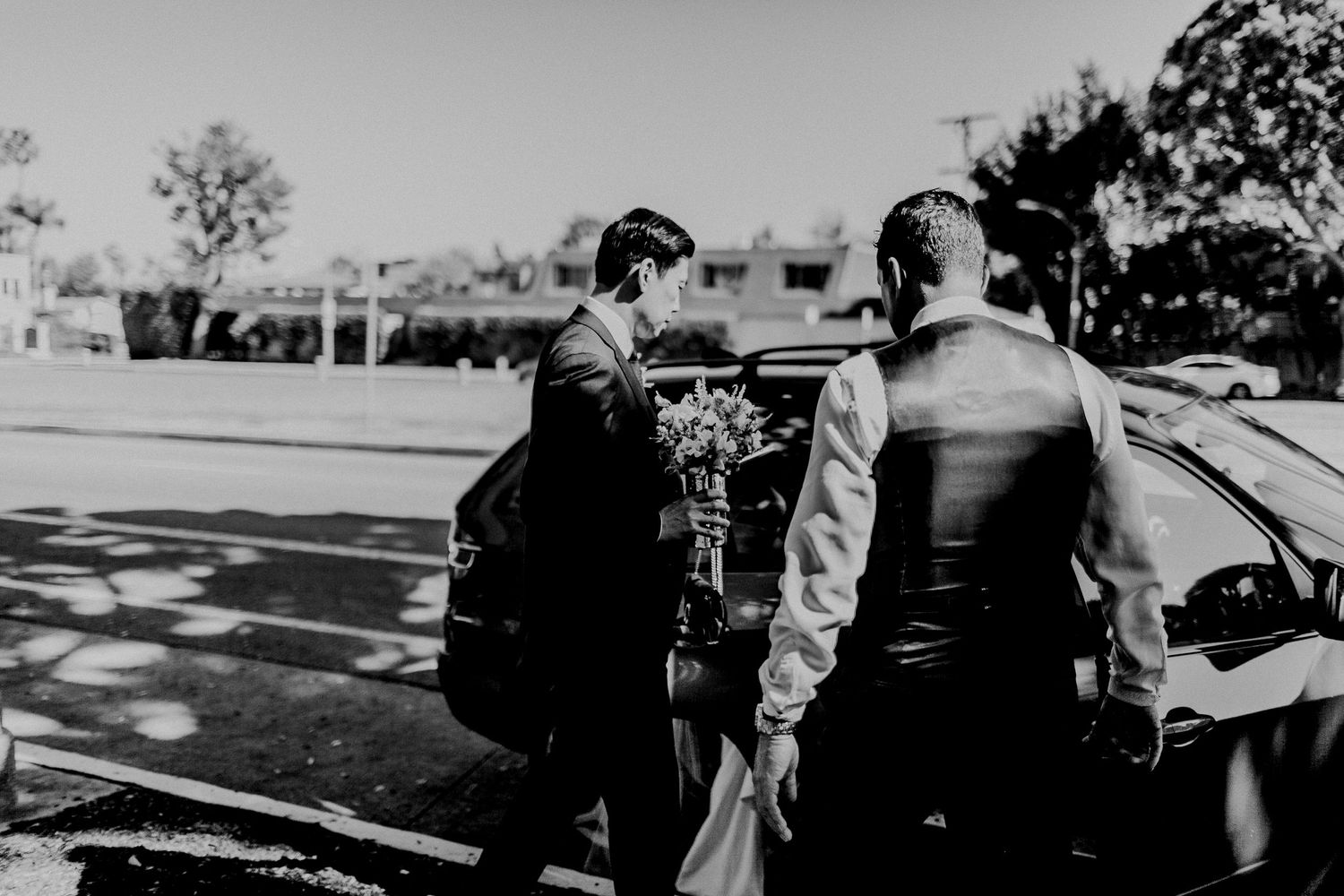 groom entering car to go to A.O.C. la for wedding ceremony and reception