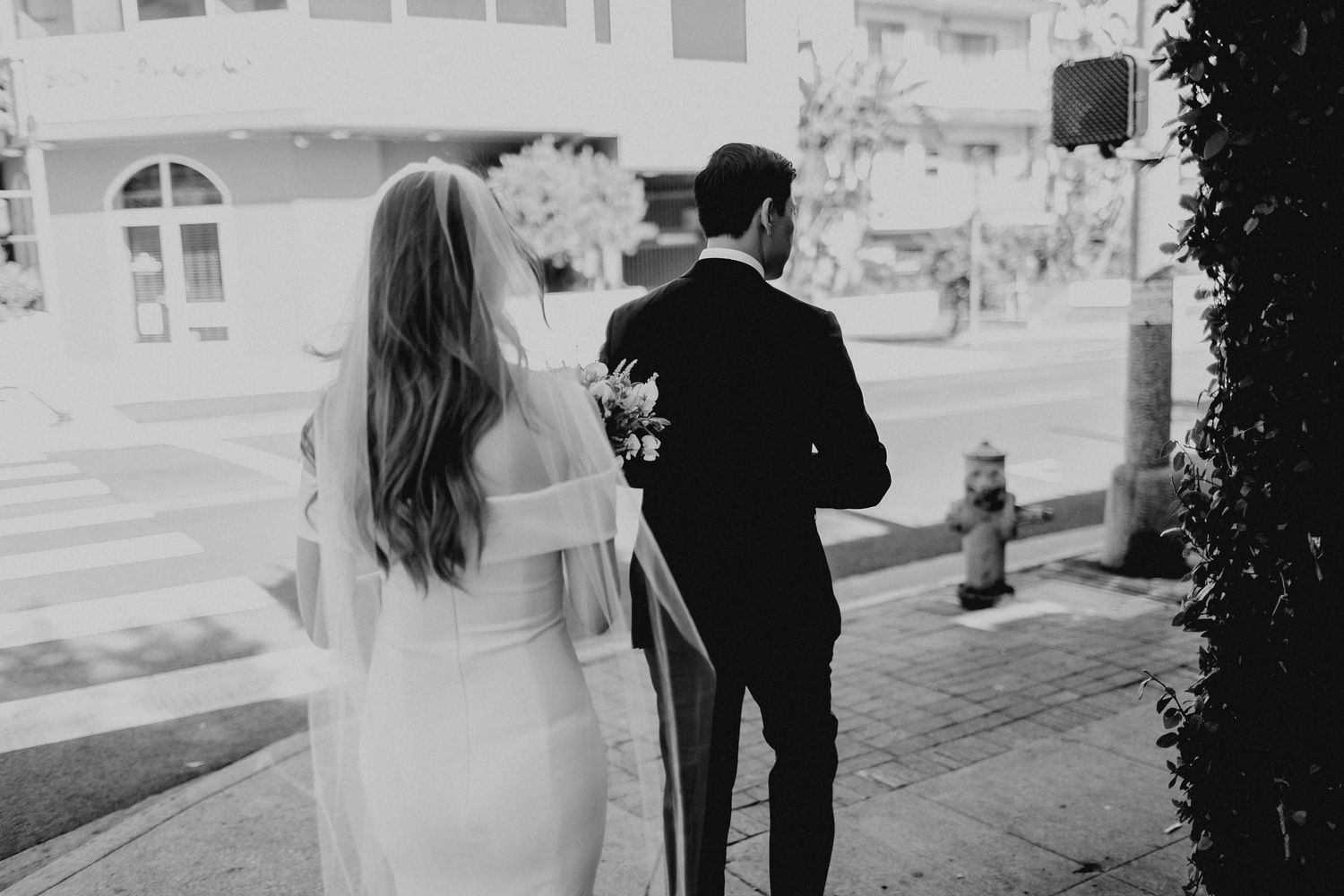 groom walking in front of bride walking around the corner