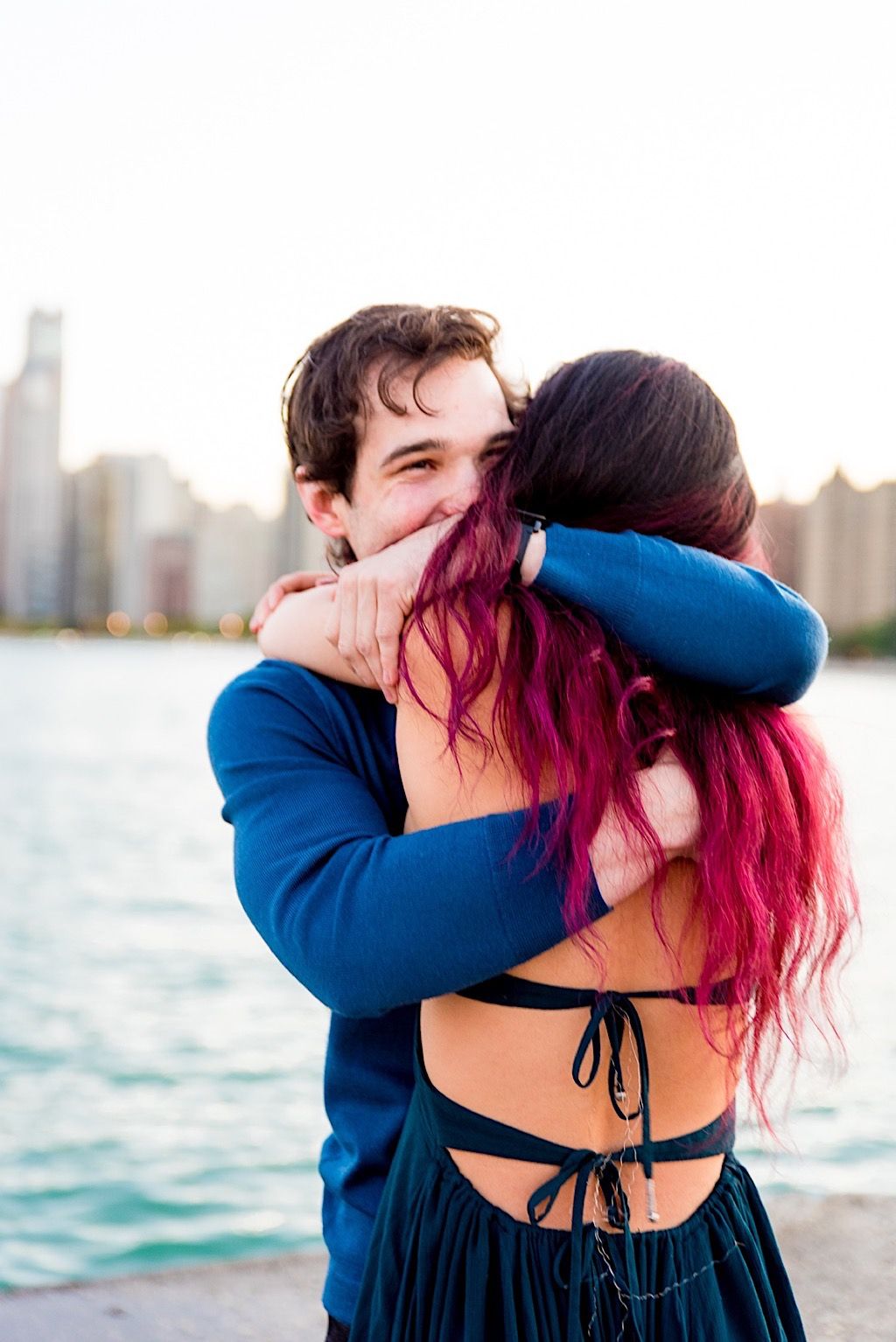 man hugs his pink haired fiancee