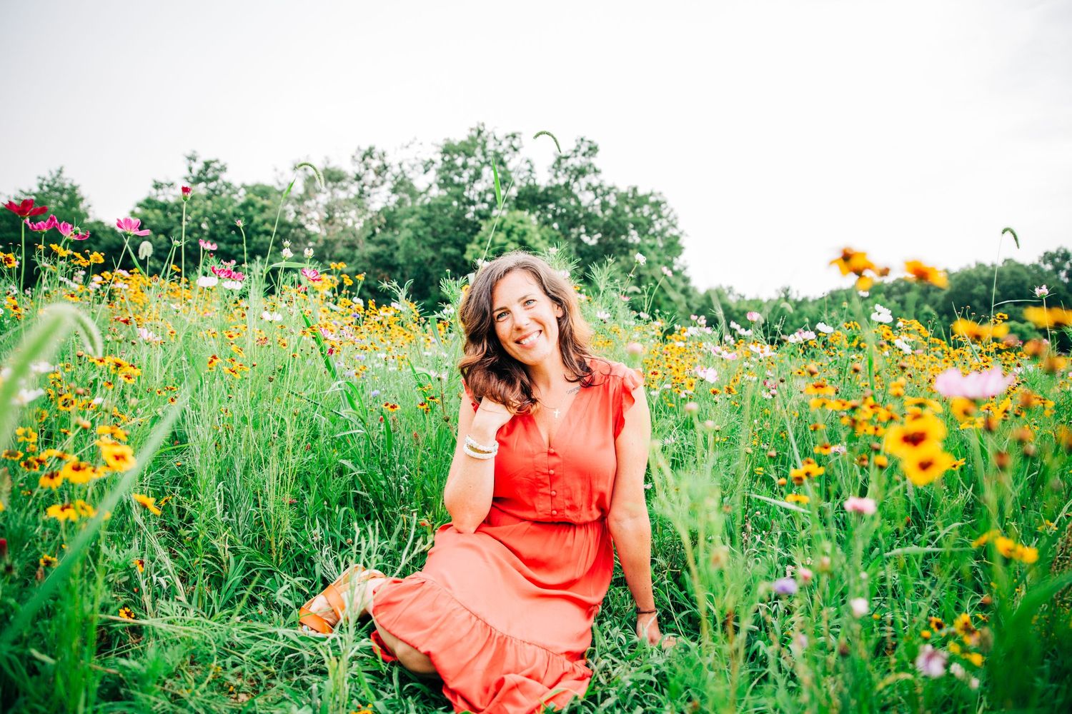 Amy of the Holistic Edit smiling in wildflowers