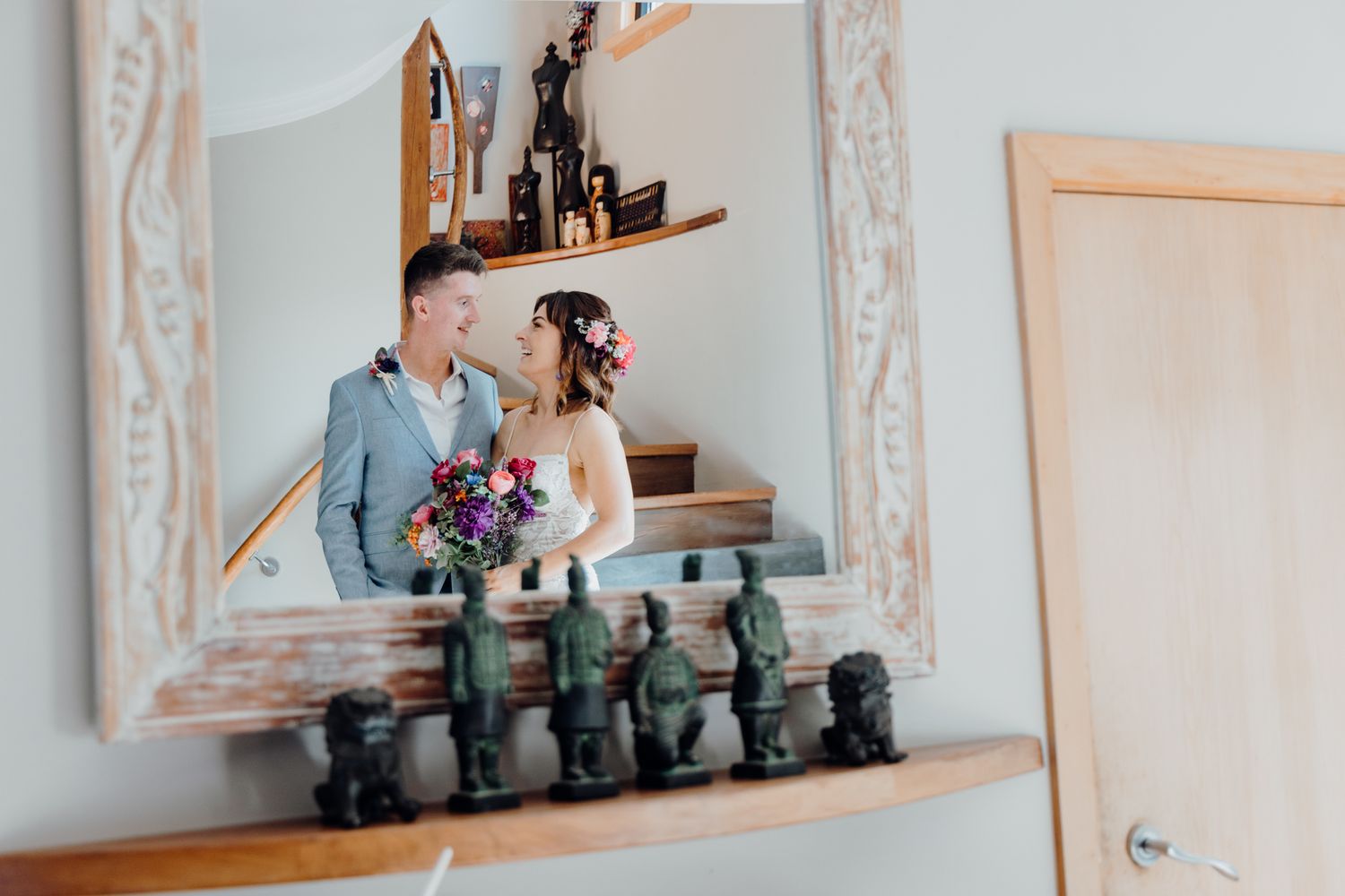 A romantic wedding portrait captured in an ornate mirror reflection with vintage decor.