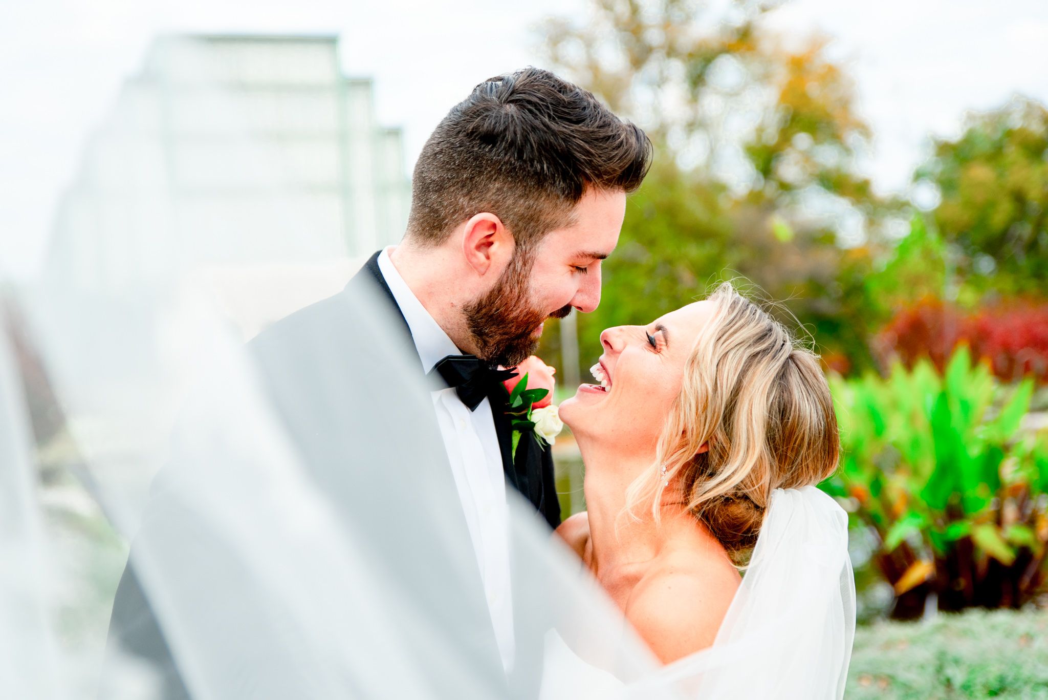 bride and groom laughing with each other in front of Jewel Box in STL Forest Park