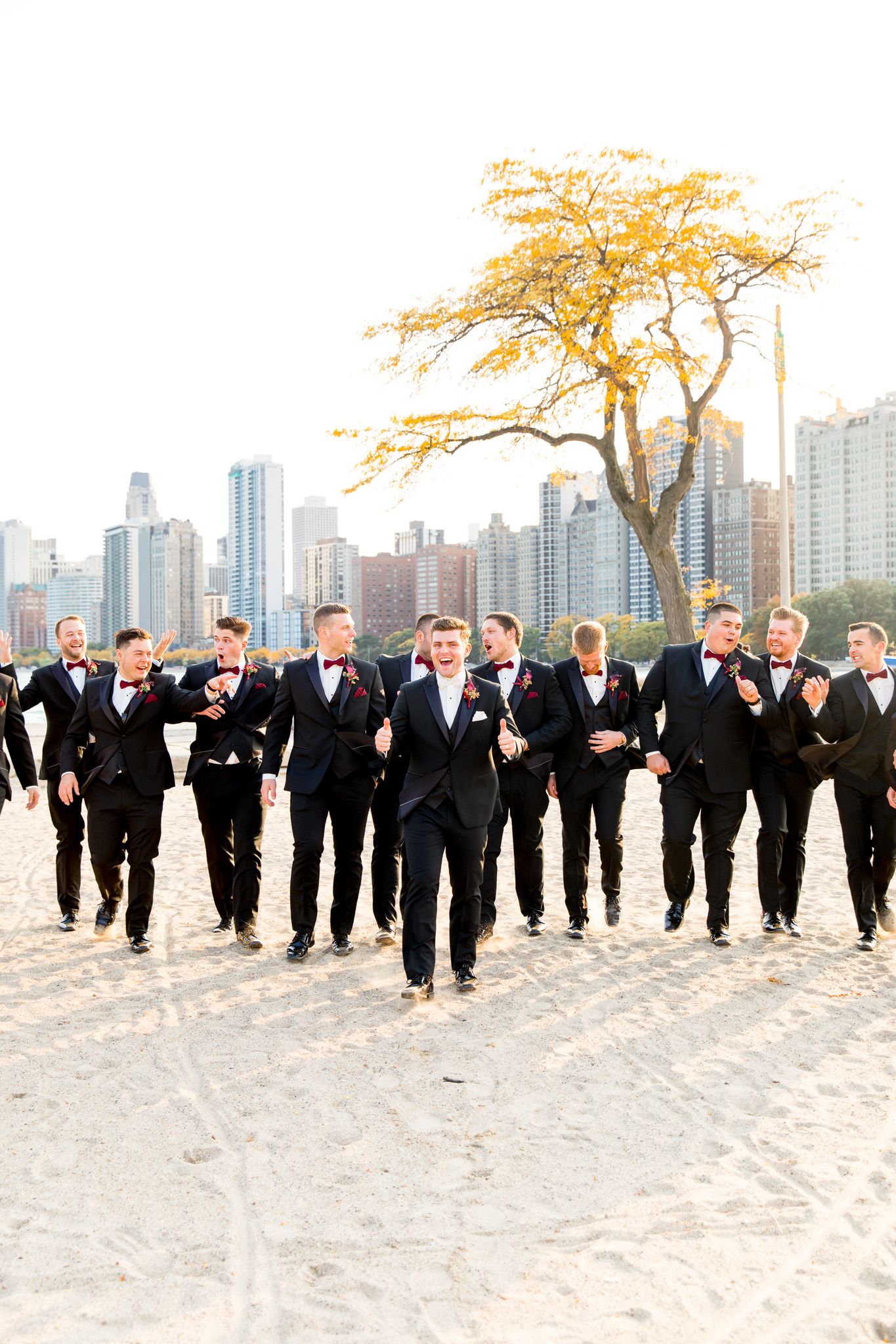 groomsmen follow groom on the beach pier for fall chicago wedding