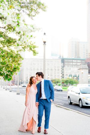 man in navy suit kisses his fiancee's cheek near Michigan Ave and Millennium Park for downtown Chicago engagement