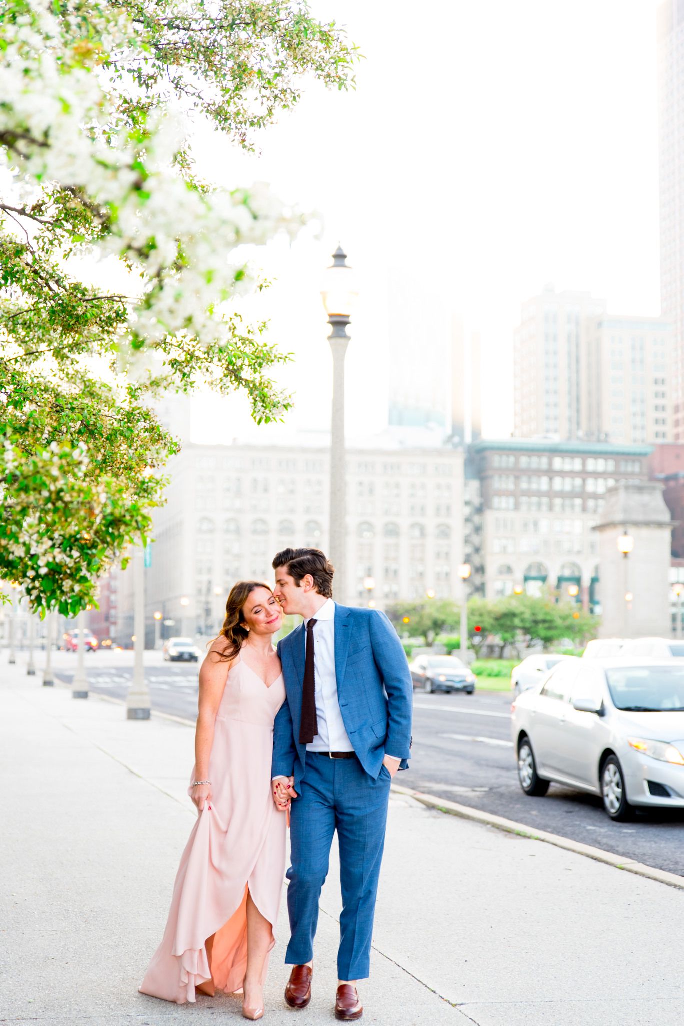 man in navy suit kisses his fiancee's cheek near Michigan Ave and Millennium Park for downtown Chicago engagement