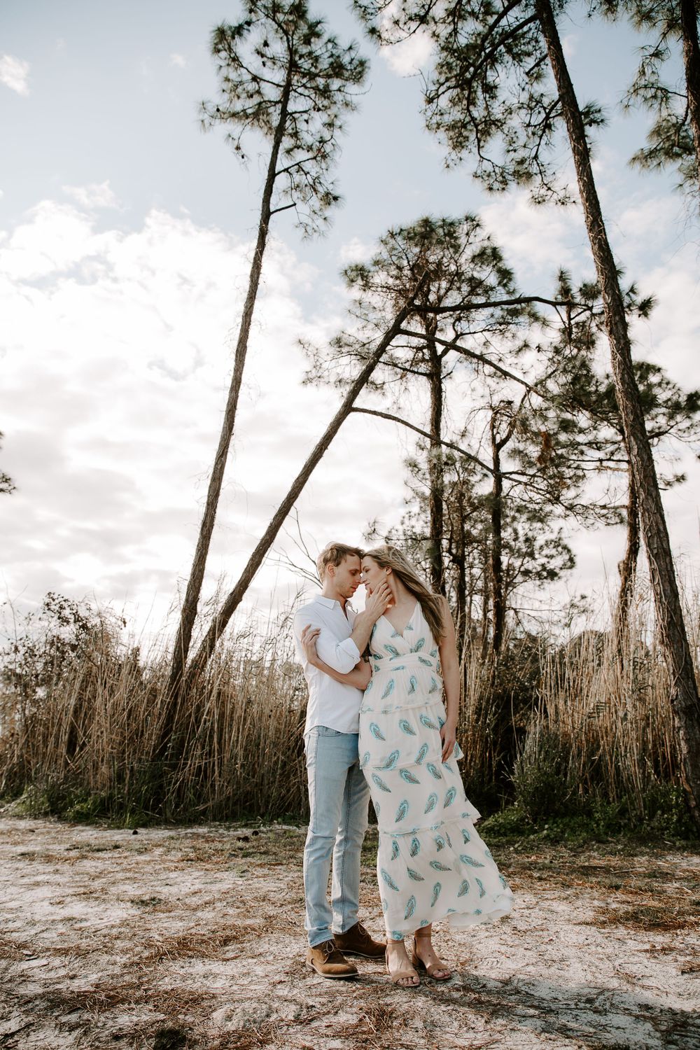 couple standing side by side with trees and greenery around them