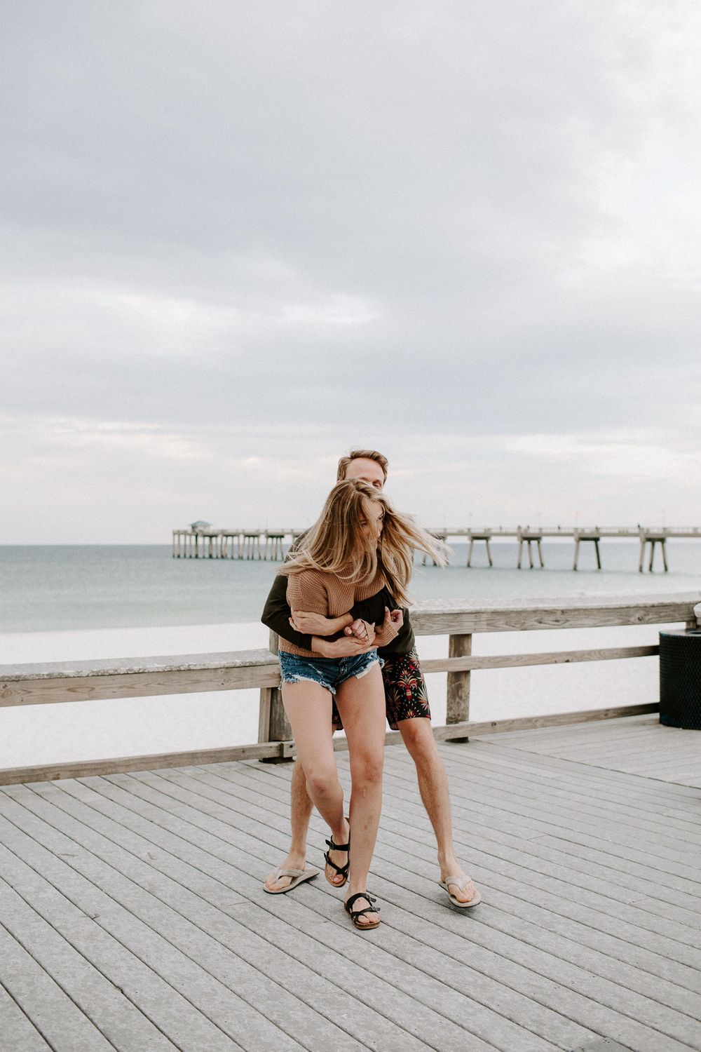 woman laughing as a man hugs her from behind