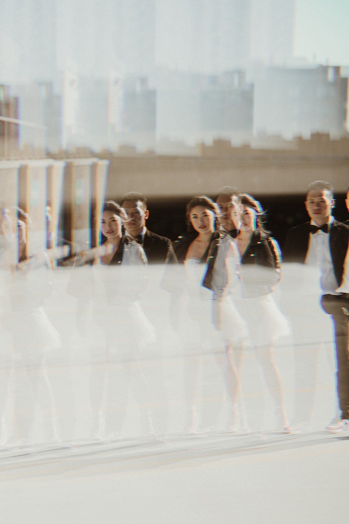 A group of people celebrate at an outdoor wedding venue with blurred ethereal effects.