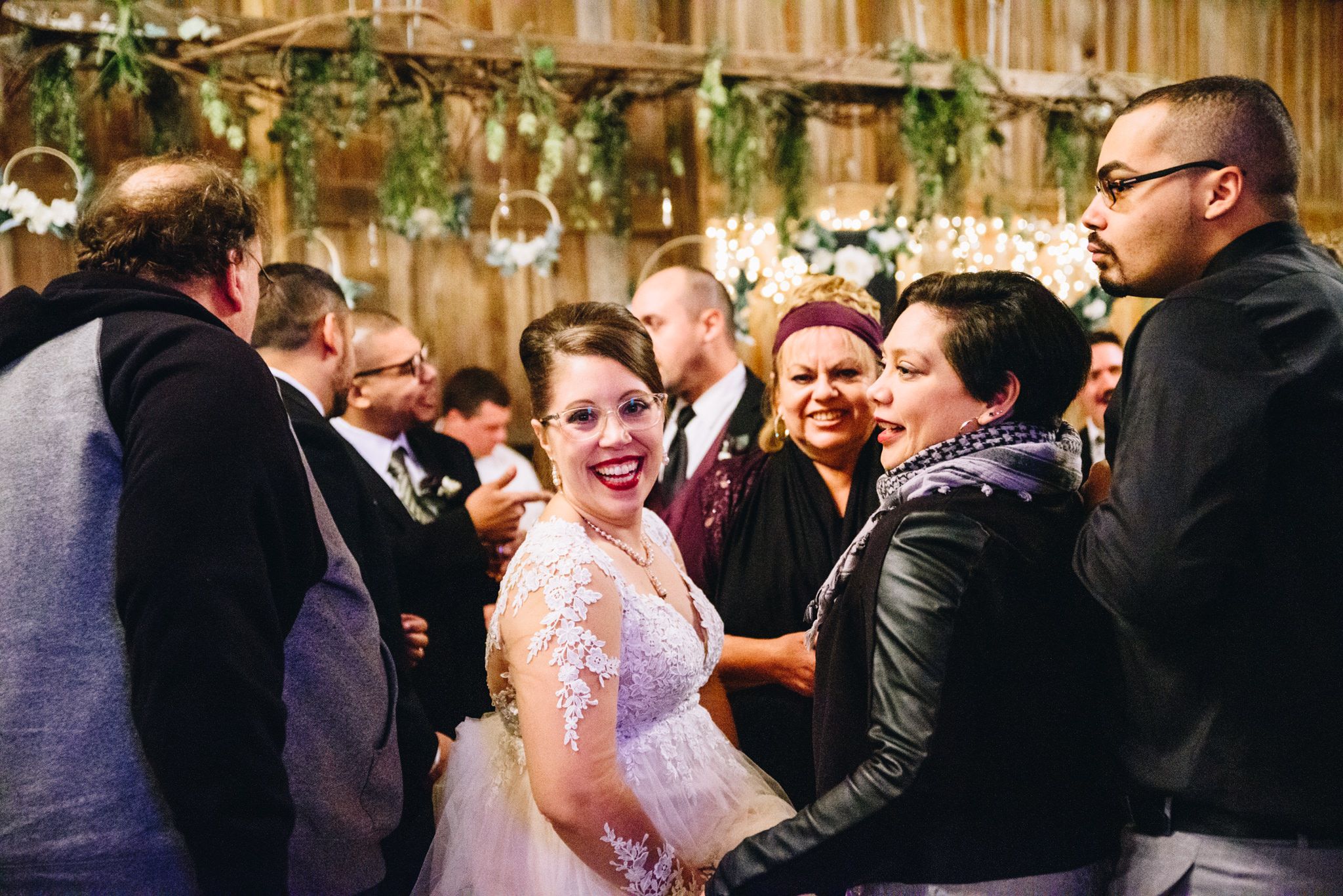 bride smiling in red lipstick in the middle of crowd at her fall wedding in Chicago