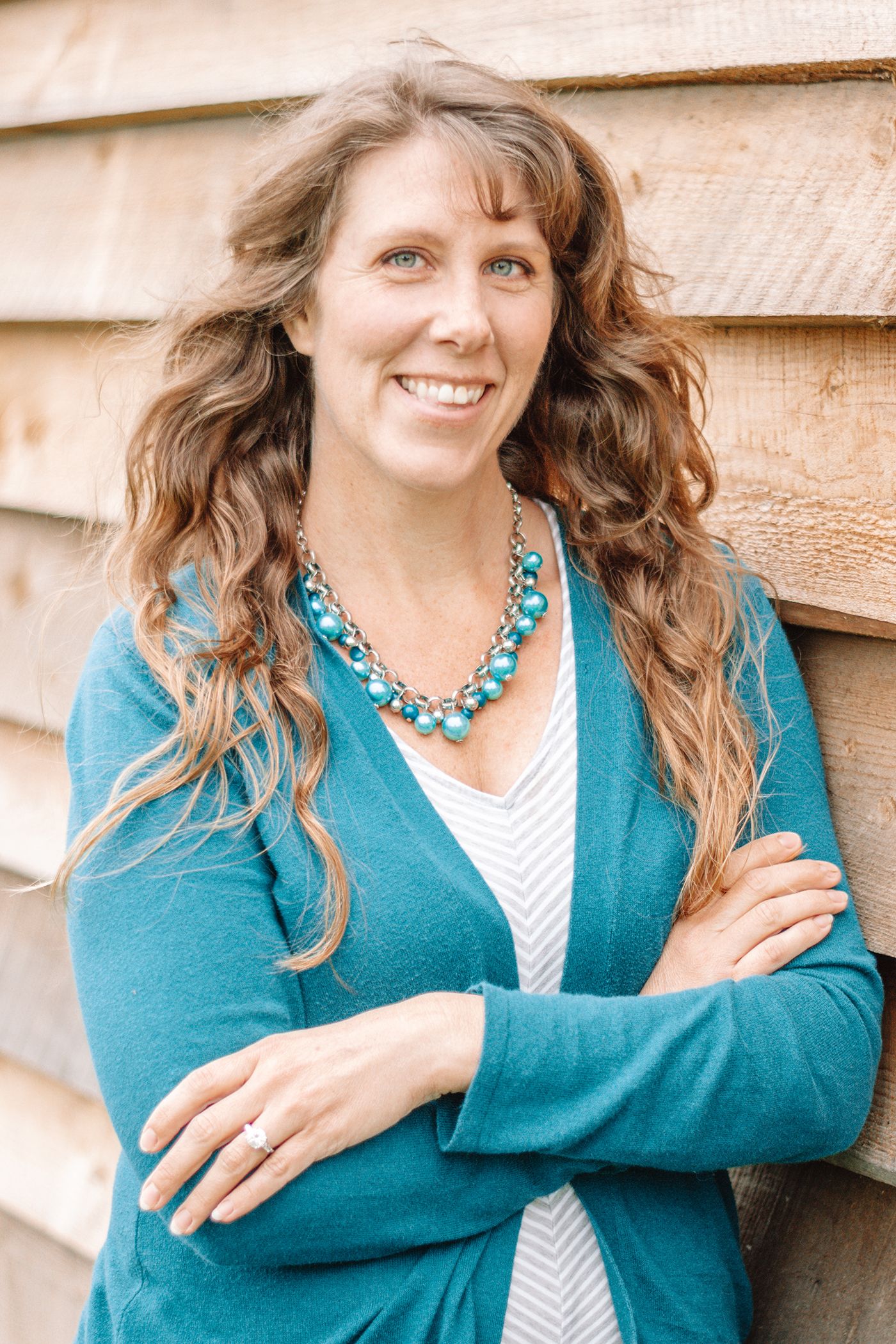 JENNIFER MADELEY a real estate agent for Coldwell Banker Select in Edinboro Pennsylvania leaning against a pretty barn w