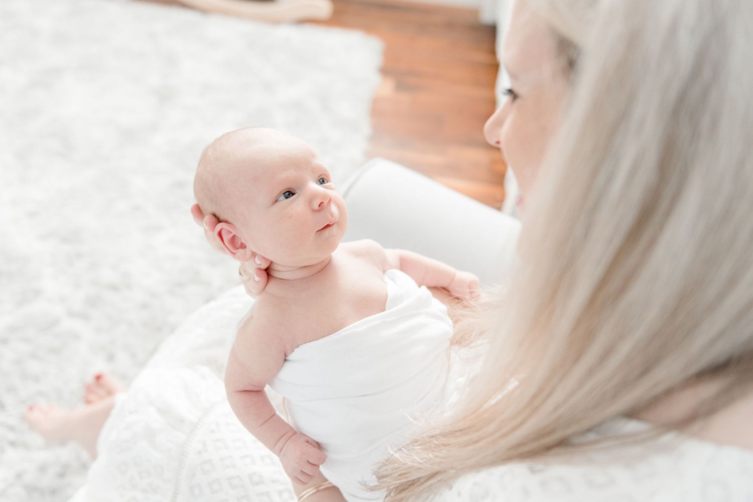 Newborn baby stares up at his mom during newborn lifestyle session