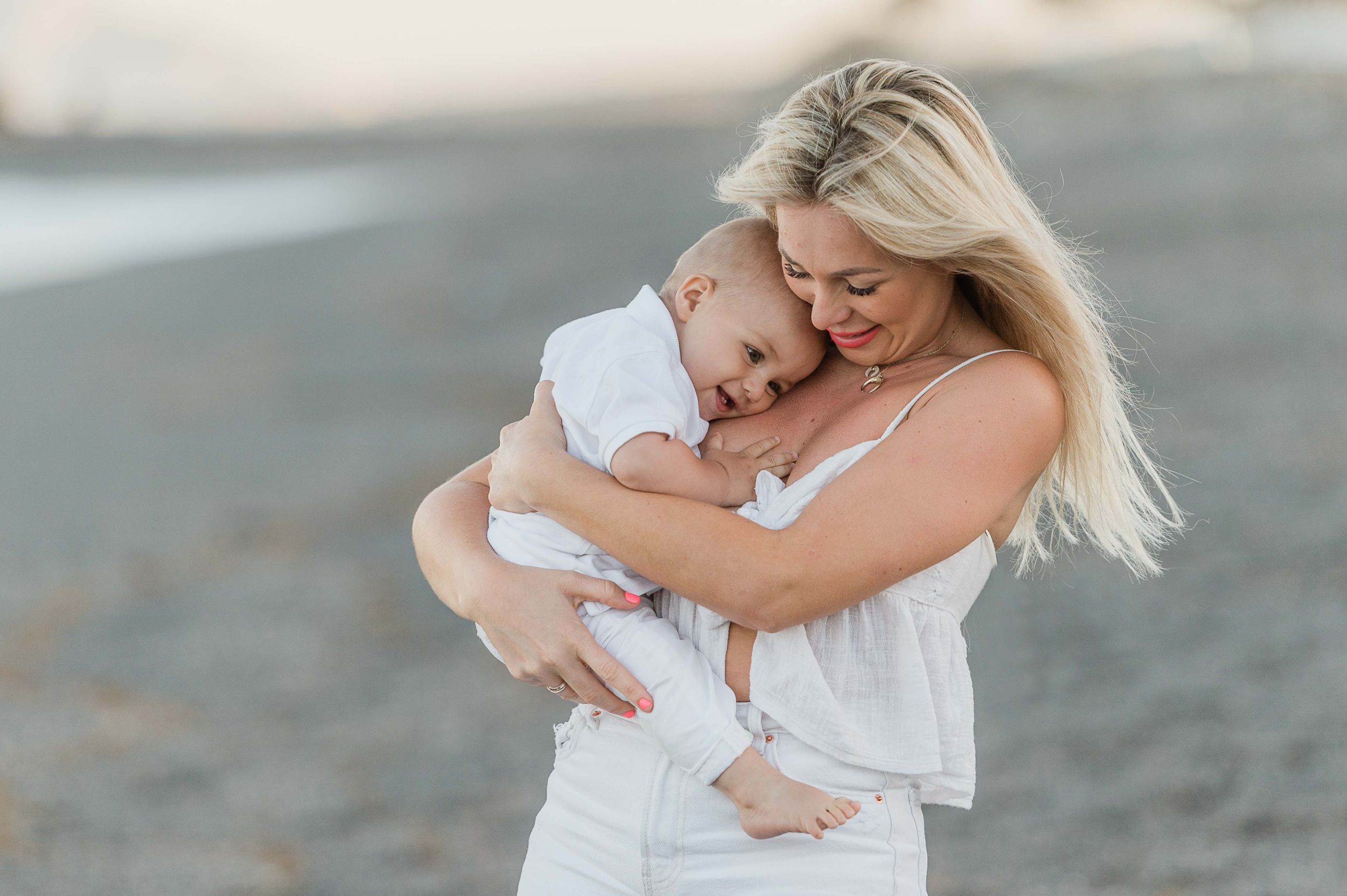Mother holding her baby on the beach