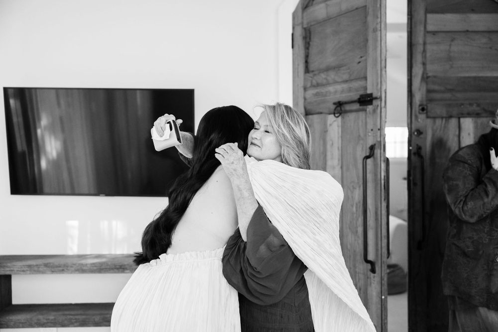 A tender moment captured in black and white during wedding preparations.