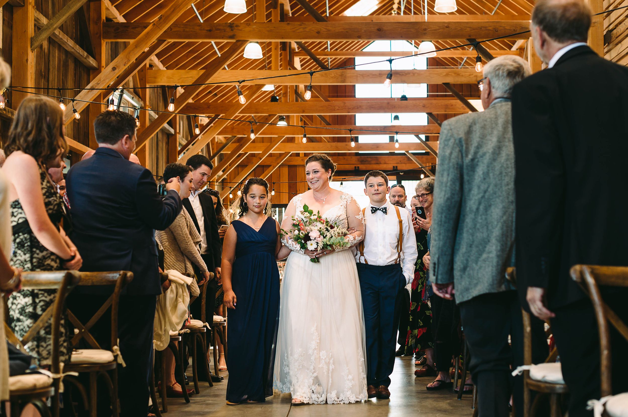 Bride being walked down the aisle at her wedding ceremony by her children
