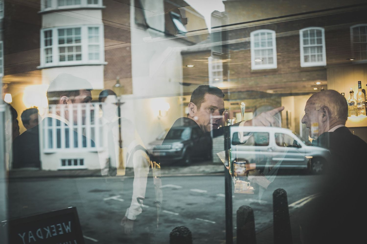 Groom pointing at The Guildhall and it's reflected in the window