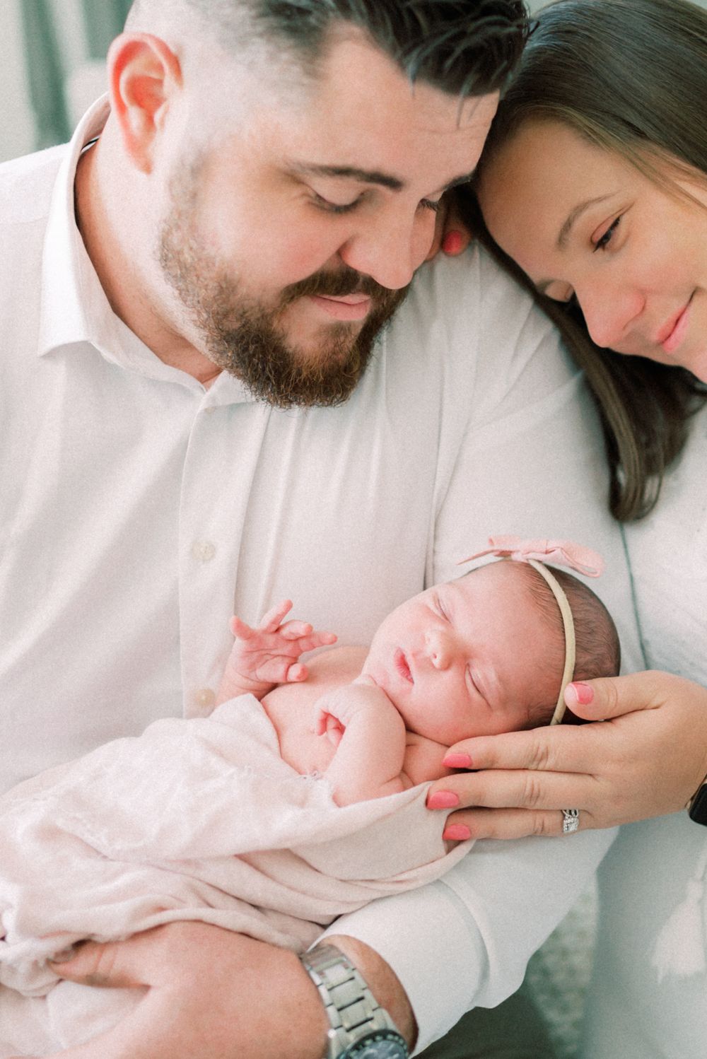 Intimate family portrait with newborn baby in soft natural light.