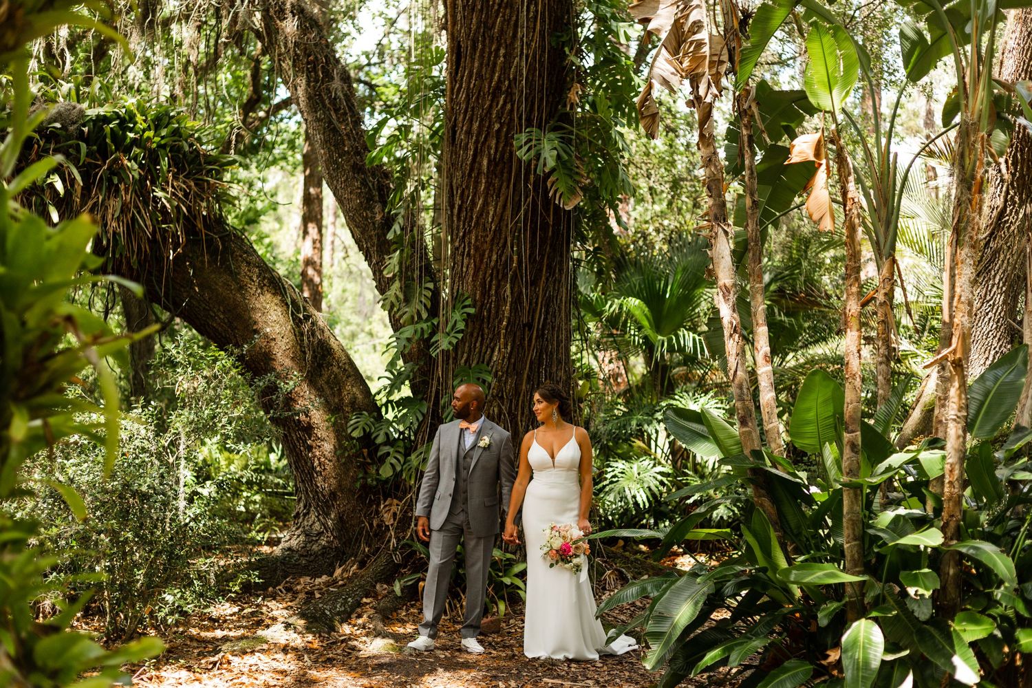 Interracial couple pose under large oak tree at eureka springs for intimate wedding ceremony taken by tampa photographer