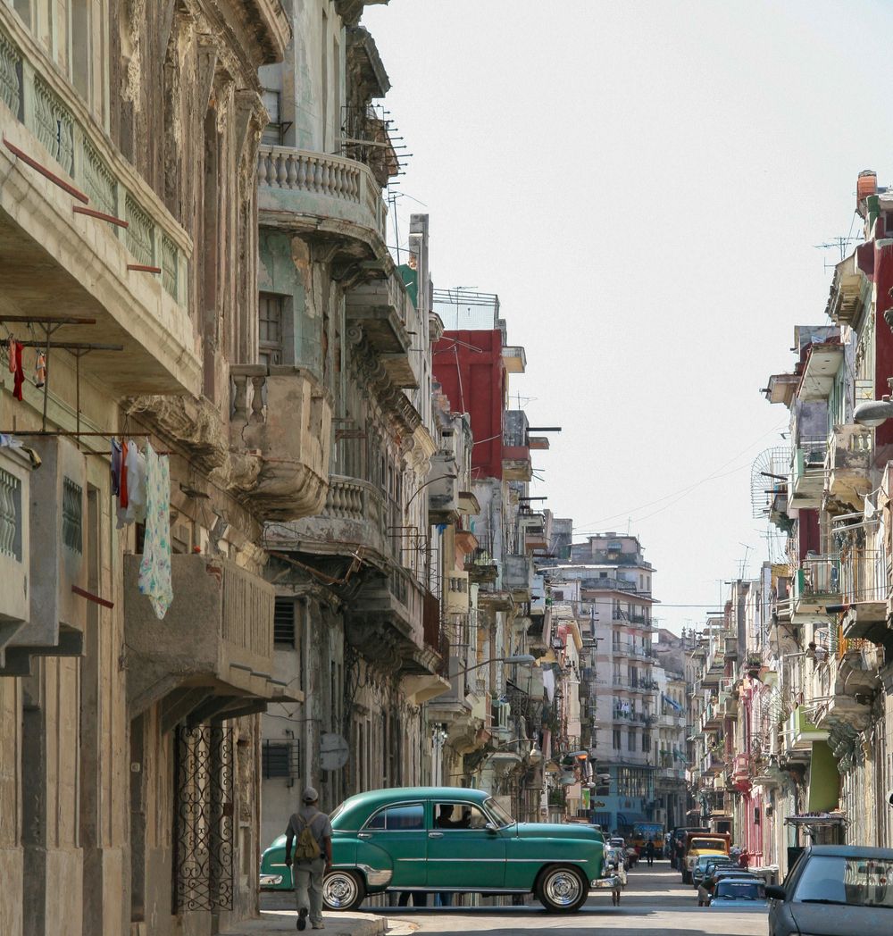 old green car from 1950's cruising along street in Havana Cuba