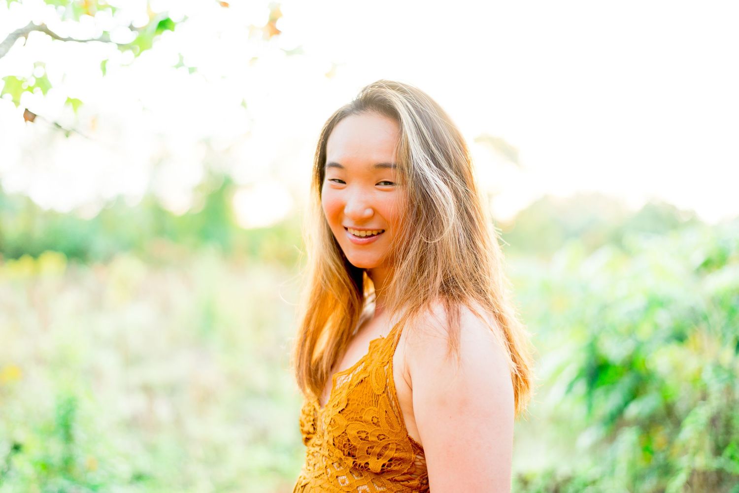 young Asian woman in yellow lace dress smiling