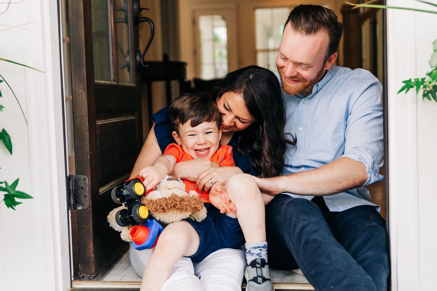 A cute Sedgefield Charlotte family cuddling on their front door opening