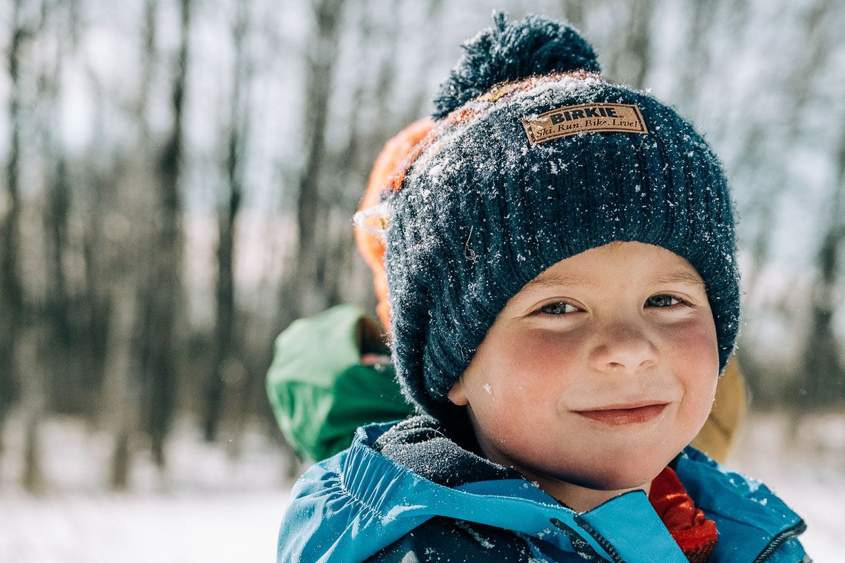 A photograph of a young boy snowsshoeing with his family in Duluth Minnesota