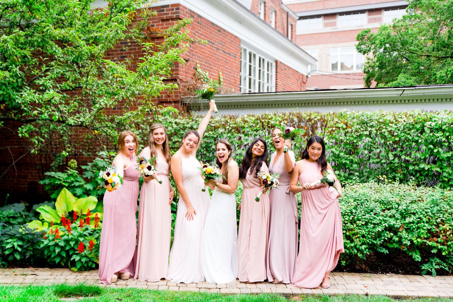 bridesmaids cheer for her bridesmaids in the garden at Woman's Club of Evanston