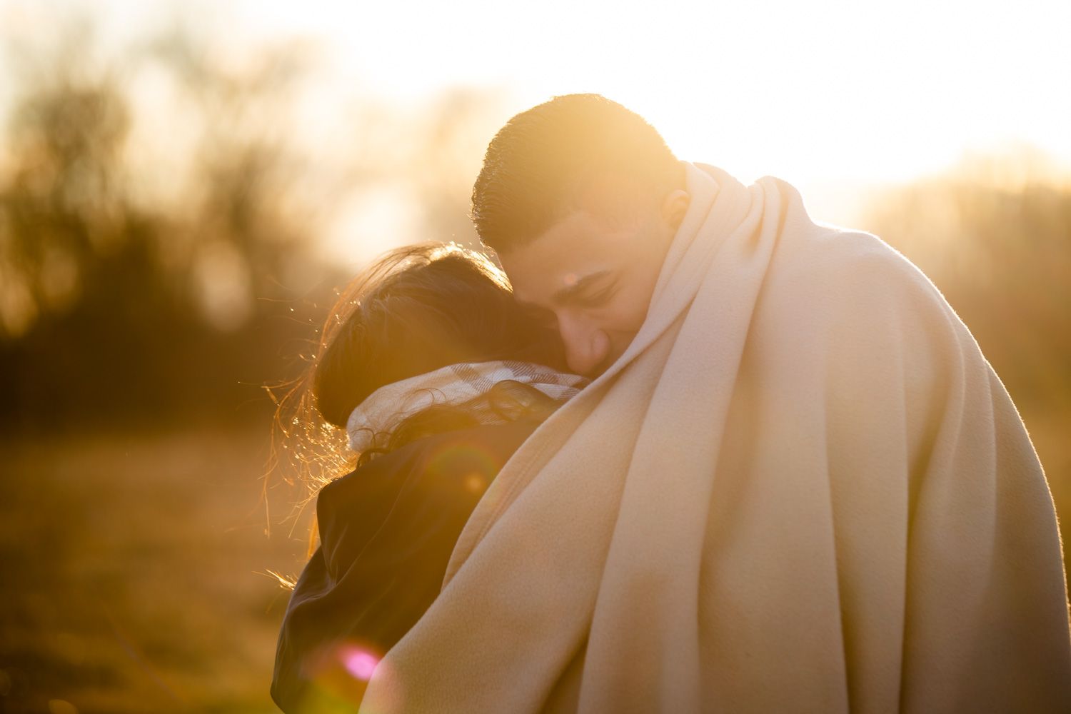Engaged couple hug in the golden hour sunset in Hudson Valley, New York