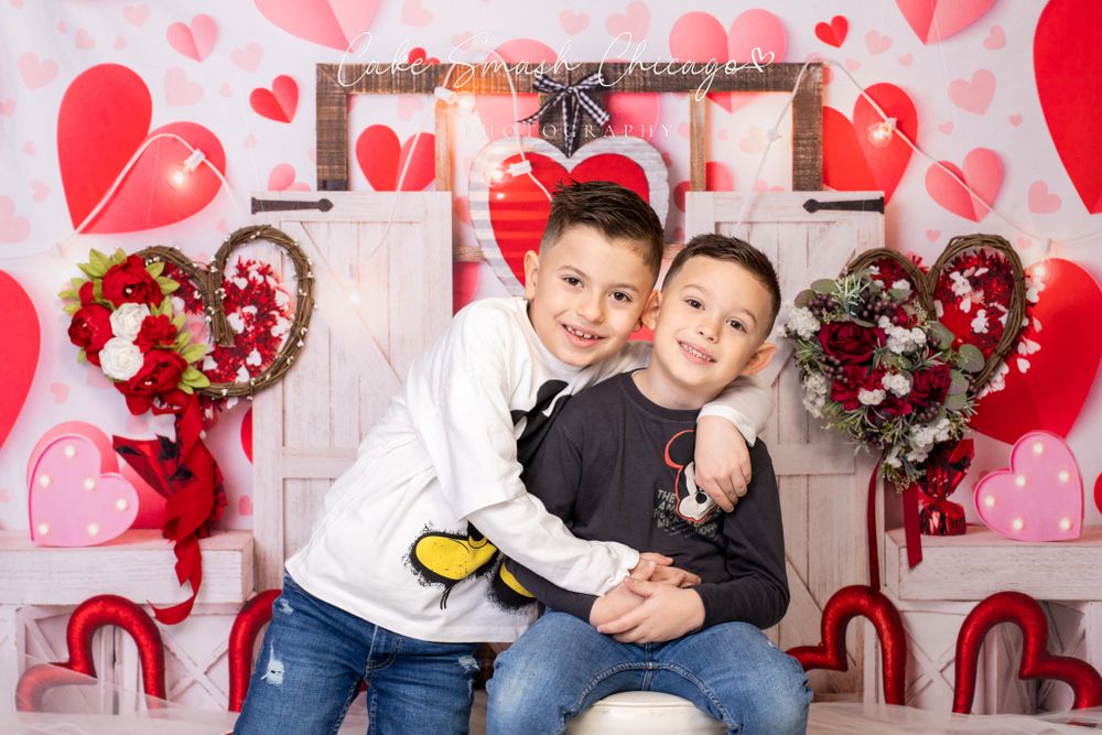 A smiling child dressed in Valentine's Day-themed outfits posing for the camera during a Valentine's mini