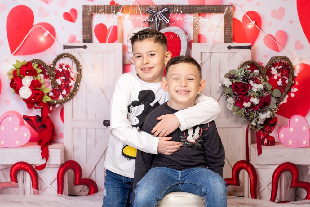A smiling child dressed in Valentine's Day-themed outfits posing for the camera during a Valentine's mini