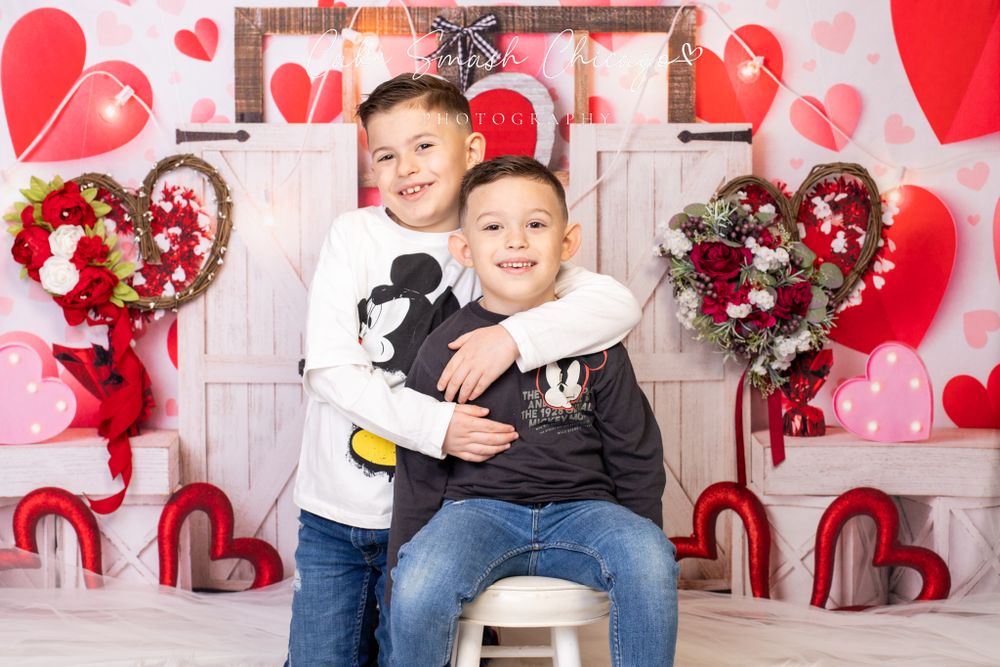 A smiling child dressed in Valentine's Day-themed outfits posing for the camera during a Valentine's mini