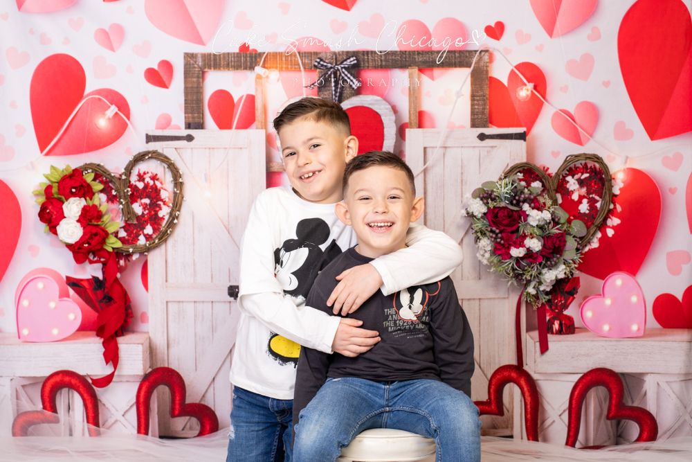 A smiling child dressed in Valentine's Day-themed outfits posing for the camera during a Valentine's mini
