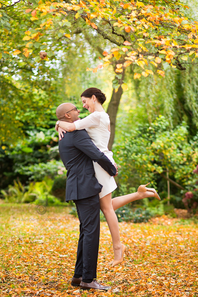 Happy wedding couple in a garden with beautiful autumn colors.