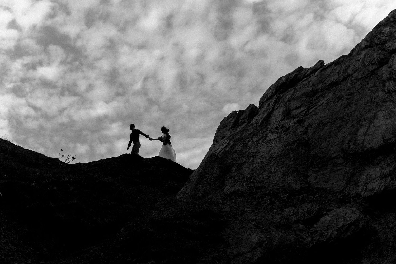 les mariés au sommet d'un rocher durant leur elopement en gaspesie, au quebec, canada