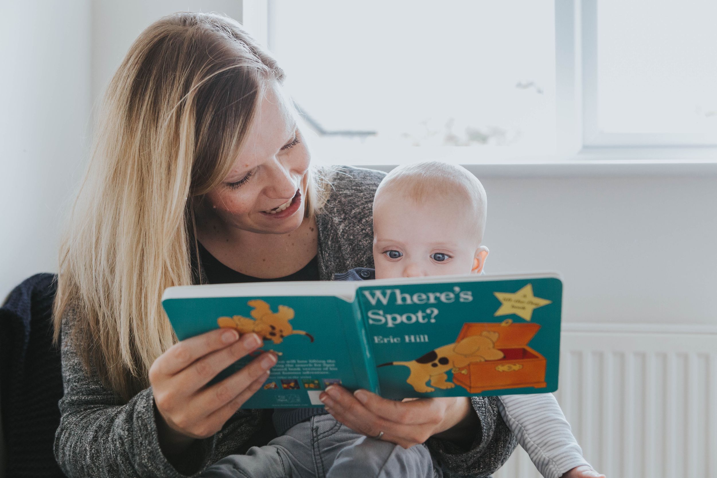 mum reading picture books to baby boy