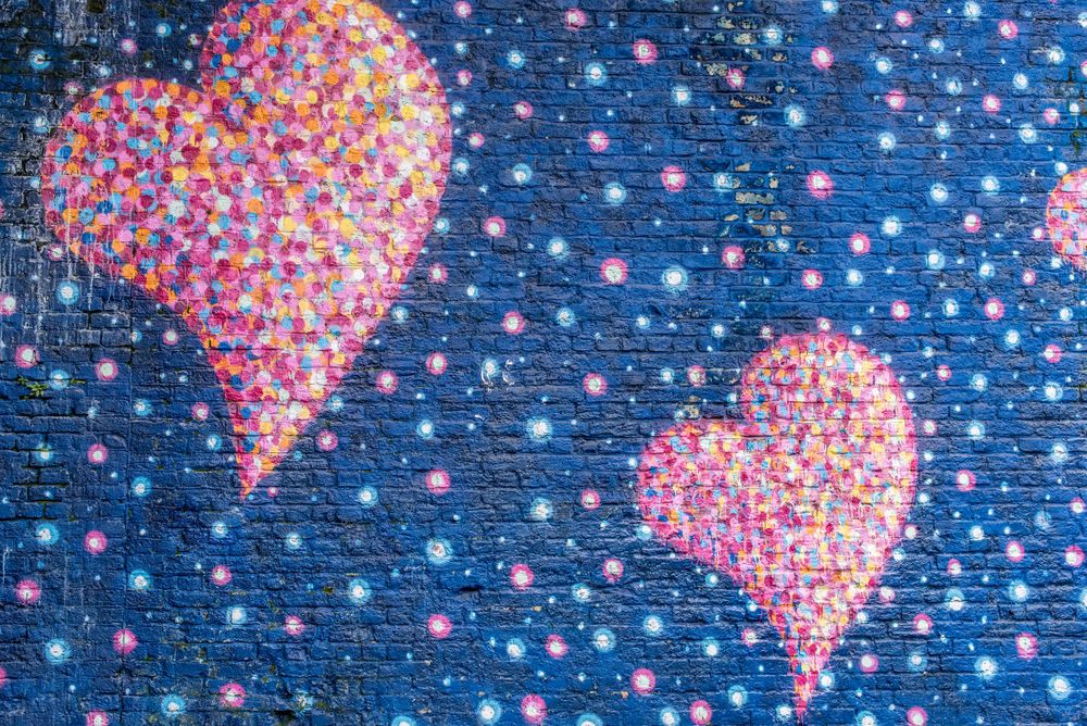 pink graffiti hearts on blue brick wall in London's Borough Market area