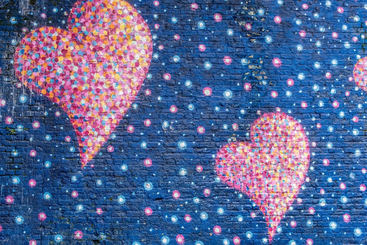 pink graffiti hearts on blue brick wall in London's Borough Market area