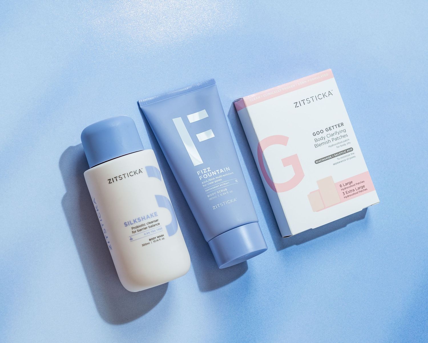 Collection of Zitsticka skincare products and packaging in blue and white colors.