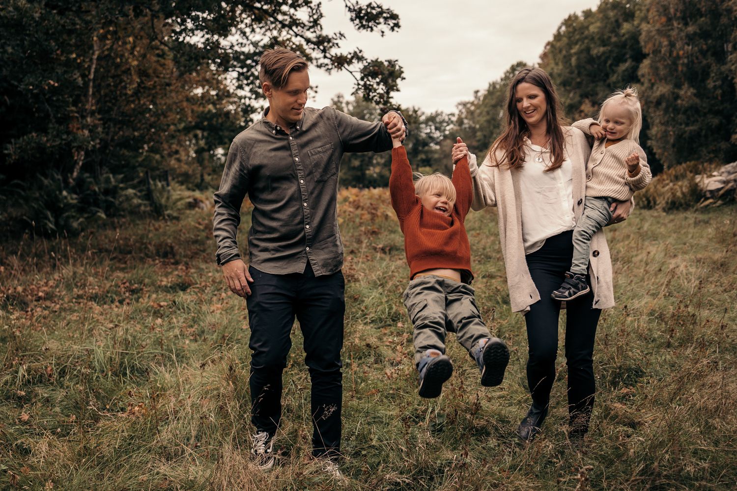 Lekfull fotografering av familj på Björnö. Barnet skrattar.