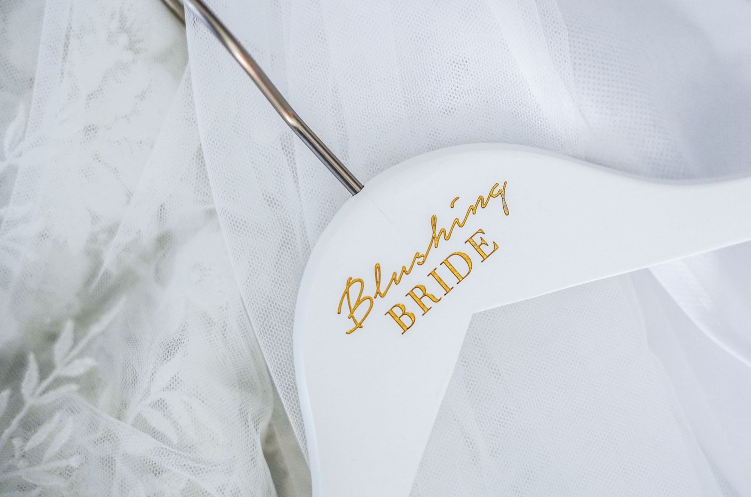 Close-up of white bridal accessory with gold 'Bride' text embossed.