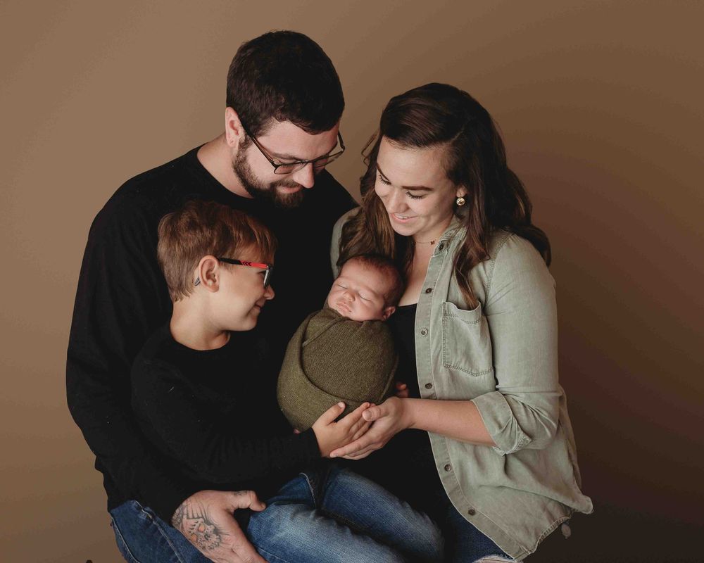Professional newborn photo with mom, dad, and big brother