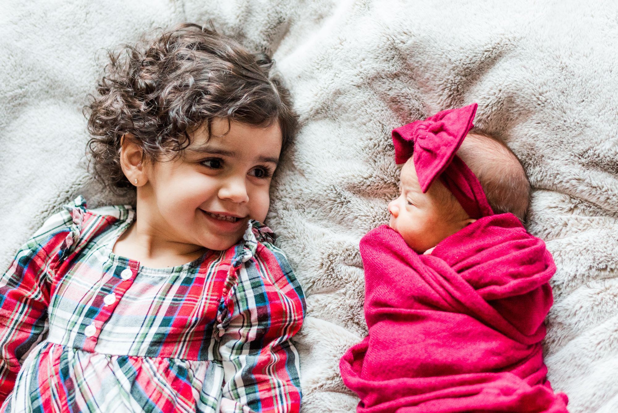 Newborn baby in pink wrap with big sister in Pittsburgh, Pennsylvania
