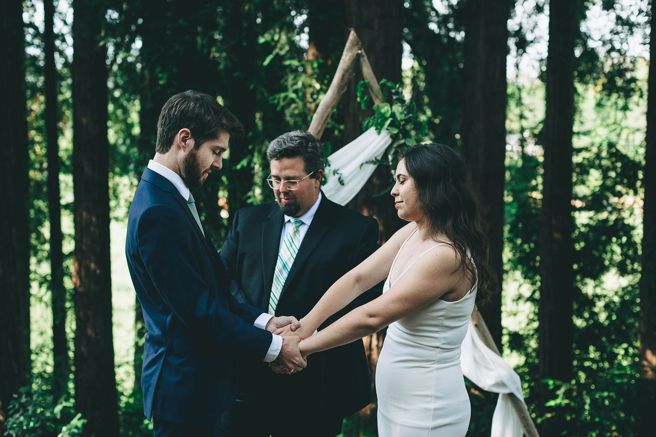 Bride and groom holding hands during wedding ceremony.