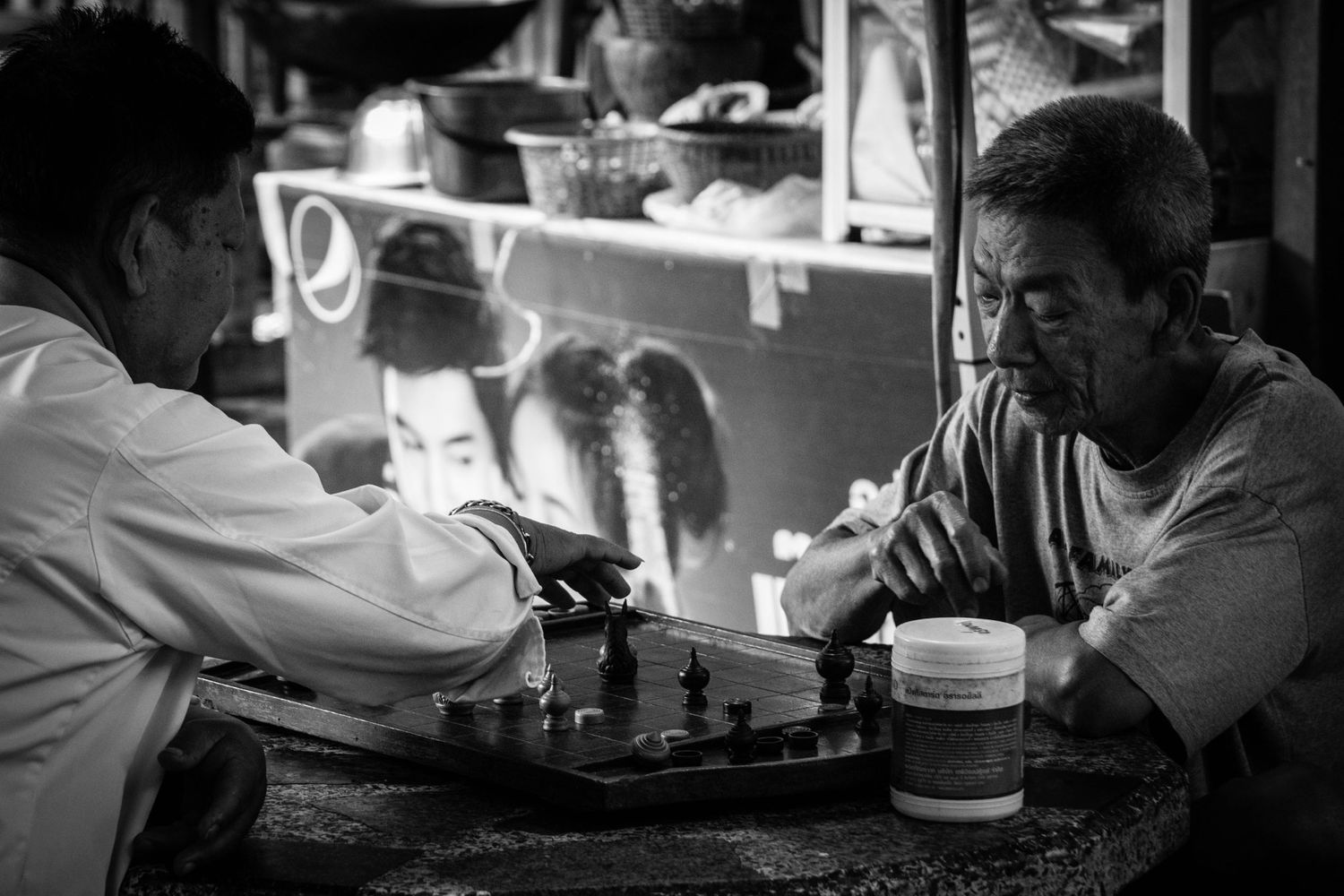 Black and white environmental portrait of two men playing chess in Bangkok Thailand