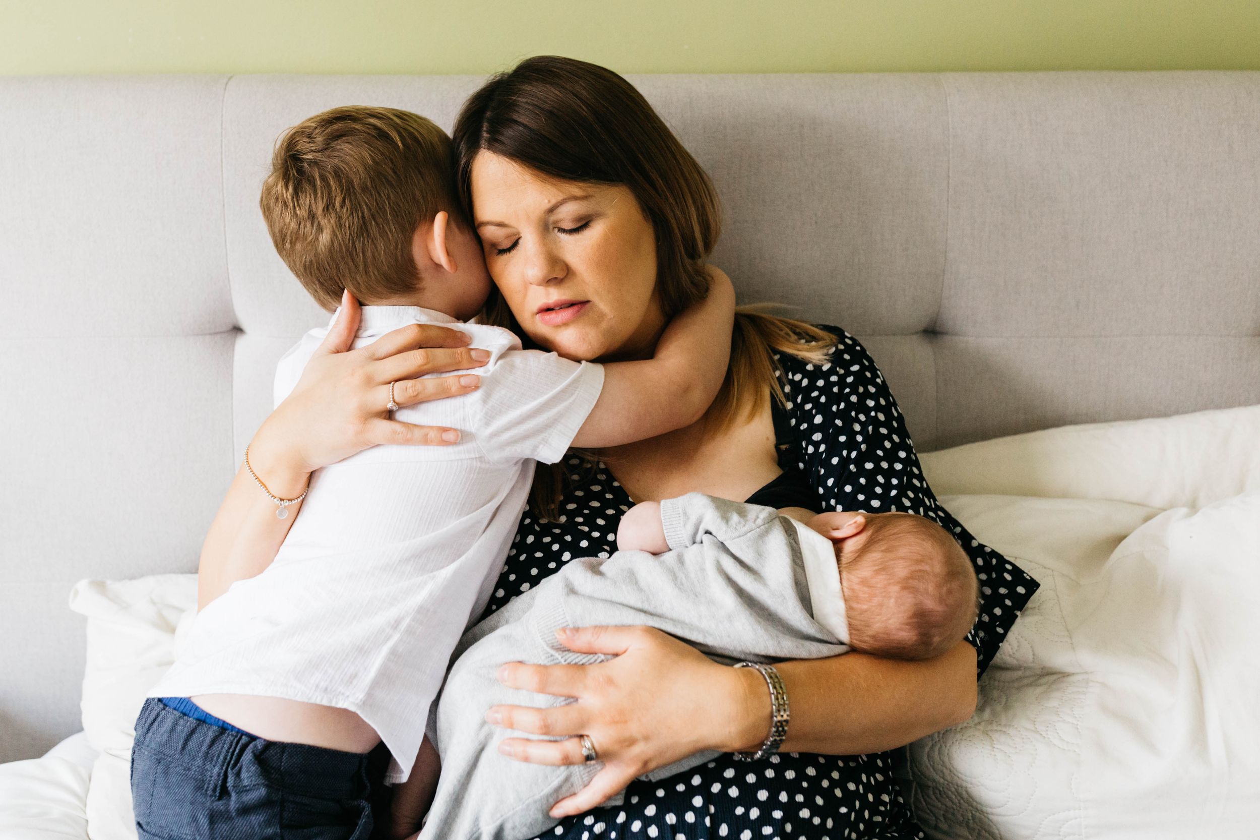 mum closed eyes hugging two sons