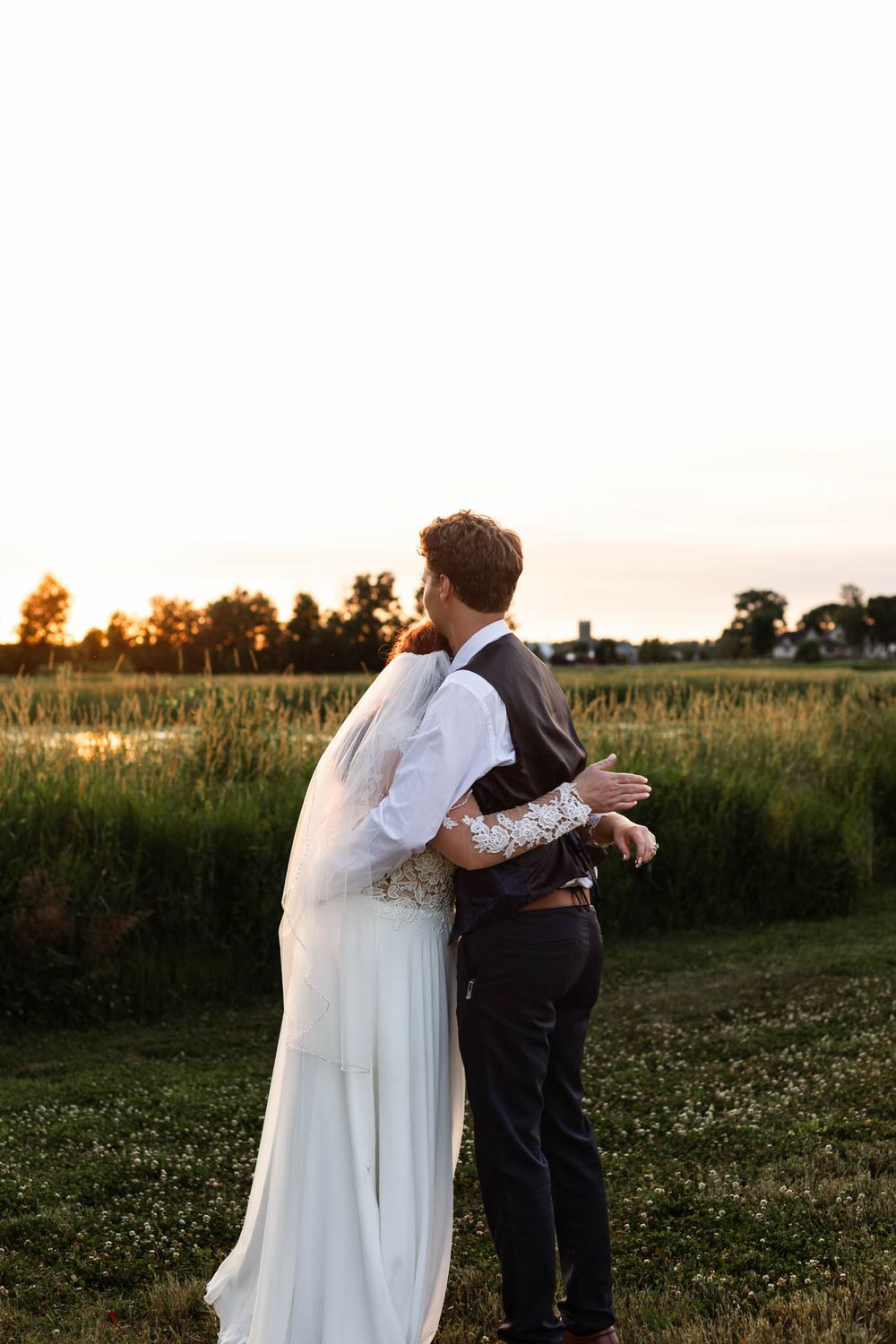 A bride and groom highlighted by the setting sun on their wedding day at Pondview Farms in Central, Minnesota
