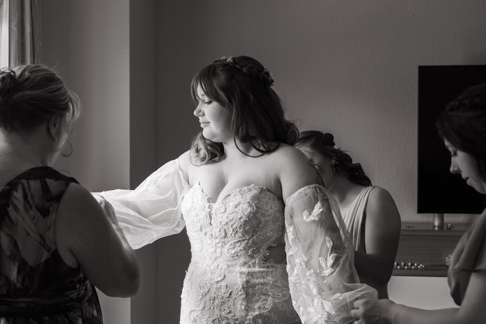 A bride getting ready for her wedding surrounded by her family and friends