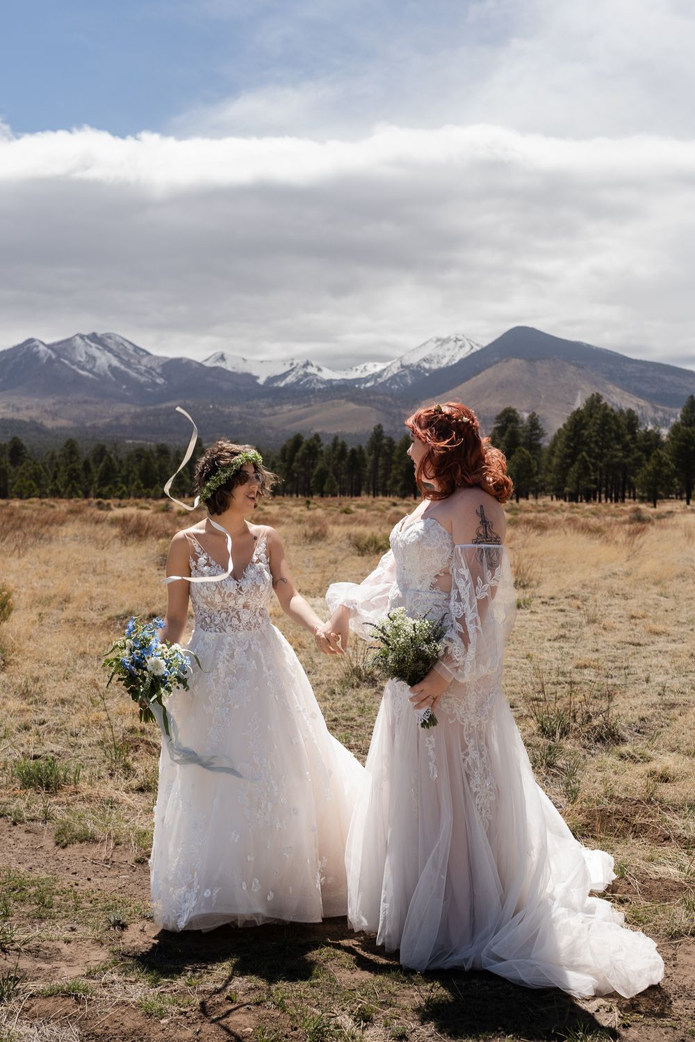 Two brides in wedding dresses staring into each other's eyes at Sunset Crater National Monument in Flagstaff, Arizona.