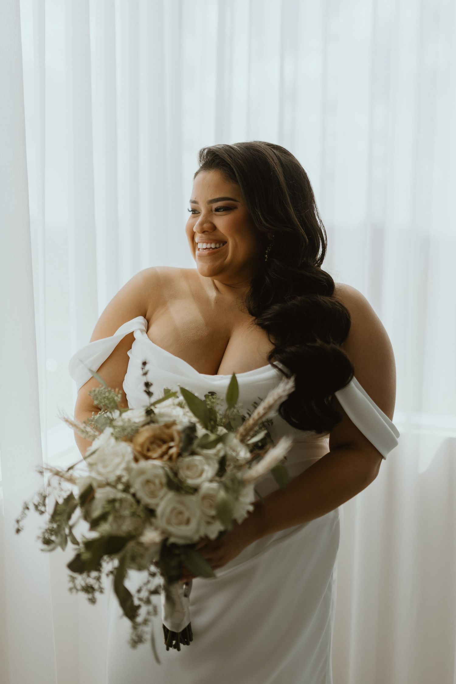 Long Island bride smiling and holding a wedding bouquet