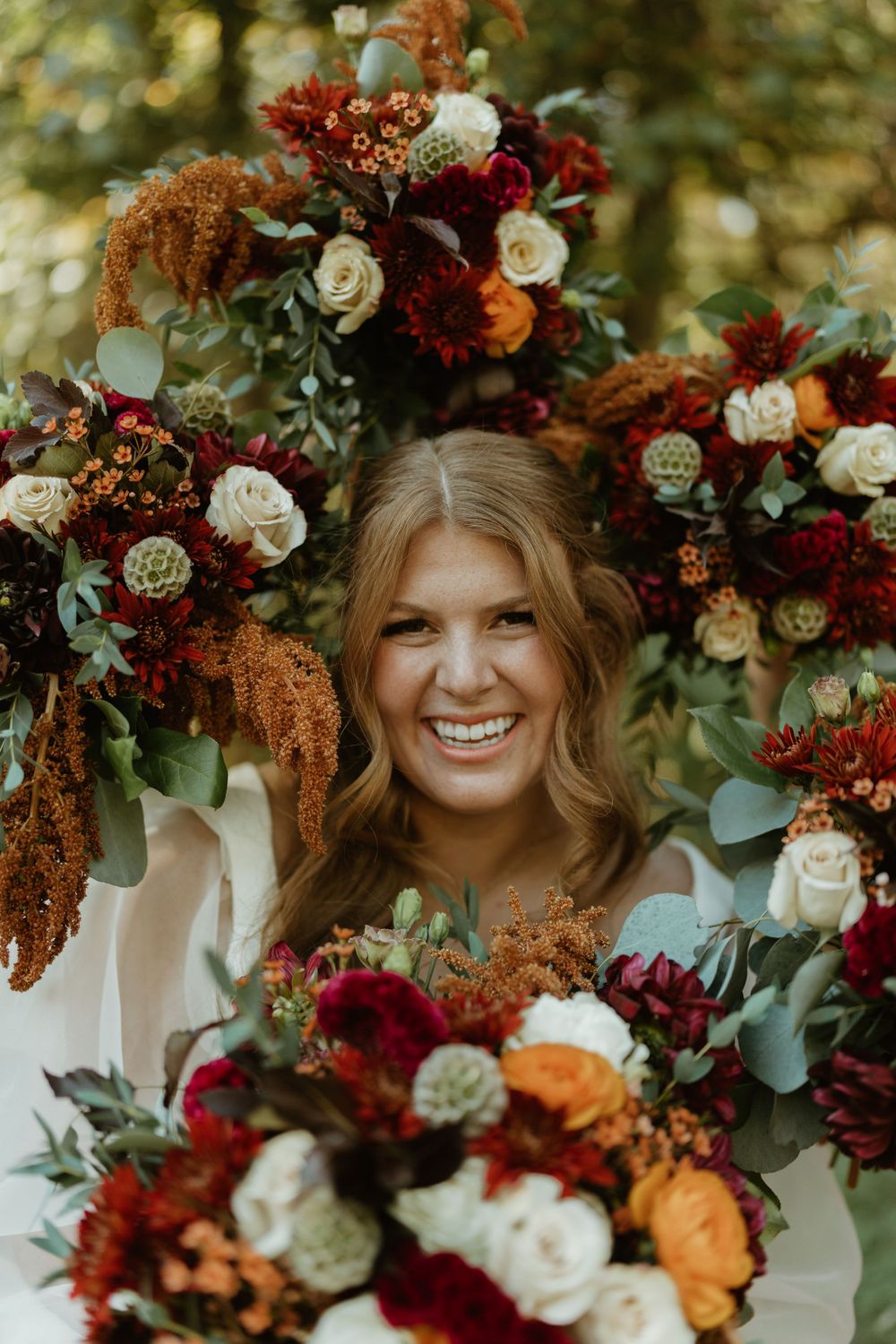 Beautiful fall wedding bouquets featuring burgundy, orange and white flowers with cascading greenery.